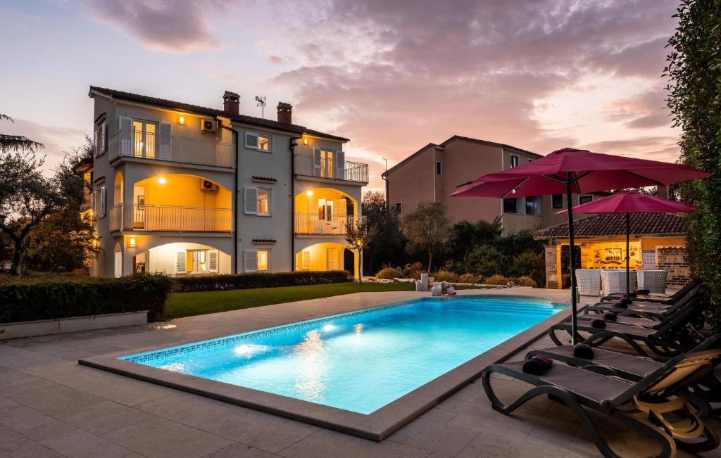 a swimming pool in front of a house at Villa Duga in Poreč