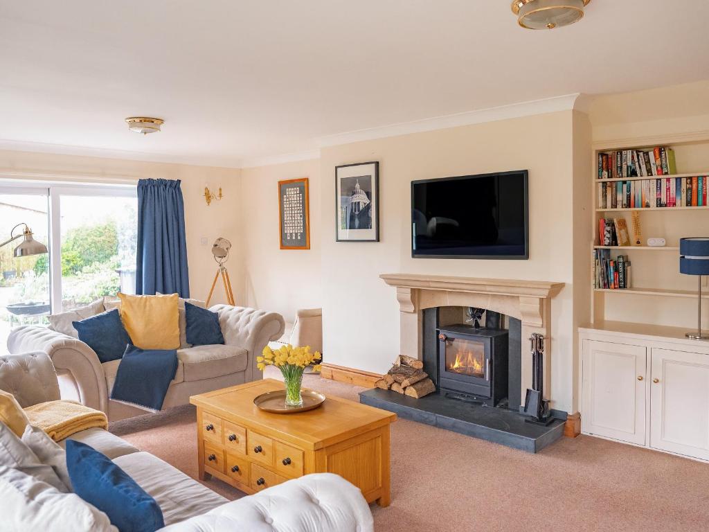 sala de estar con chimenea y TV en Cranny Hill en Walpole