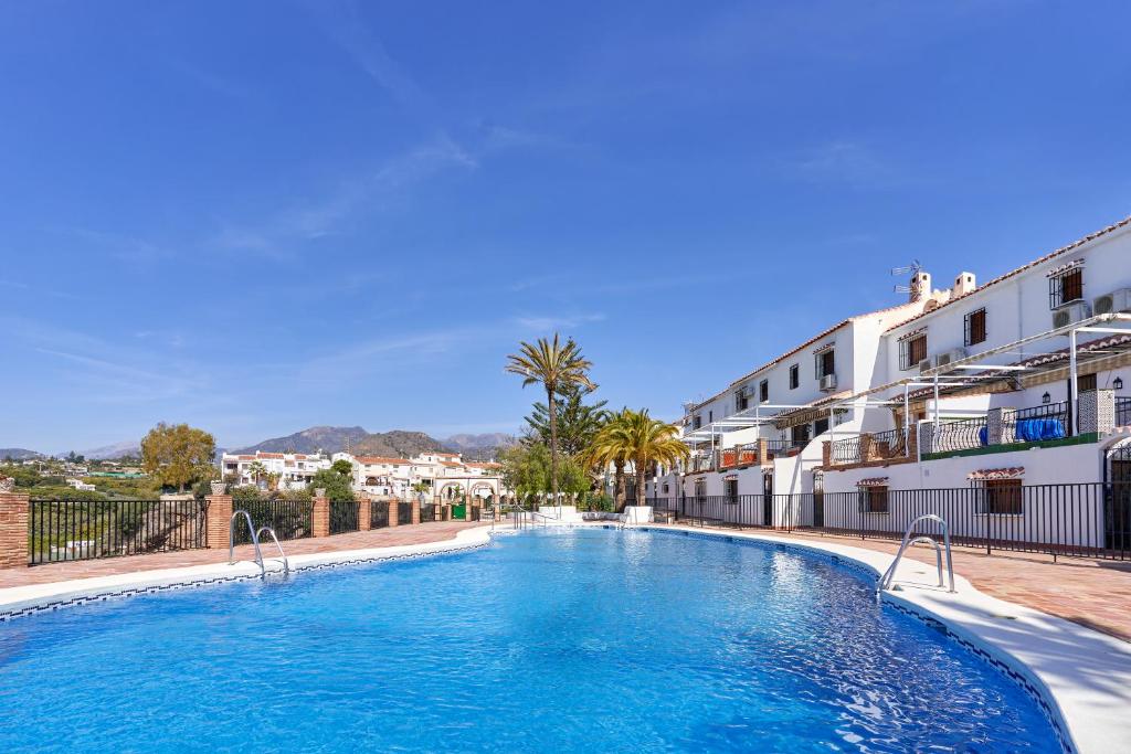 - une piscine au milieu d'une rue avec des bâtiments dans l'établissement Apartamento Almijara 2, à Nerja