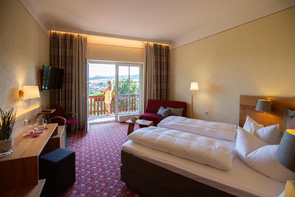フラドゥンゲンにあるHotel Sonnentauのベッドとバルコニー付きのホテルルーム