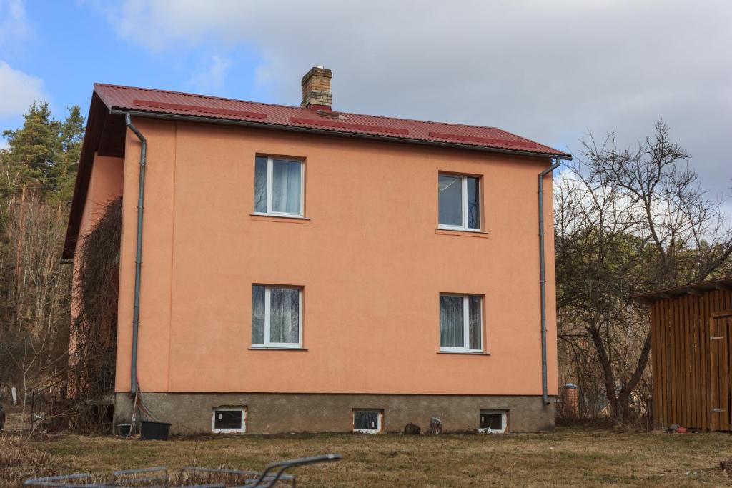 una casa naranja con techo rojo en Kalnu māja, en Krāslava