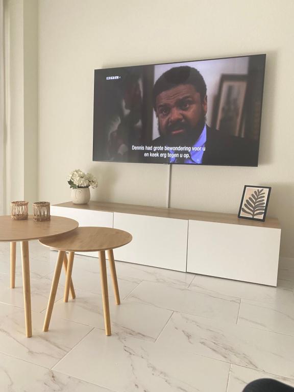 uma televisão de ecrã plano pendurada numa parede com uma mesa em Casa Bendita - LUXURY APARTMENT BENIDORM em Benidorm