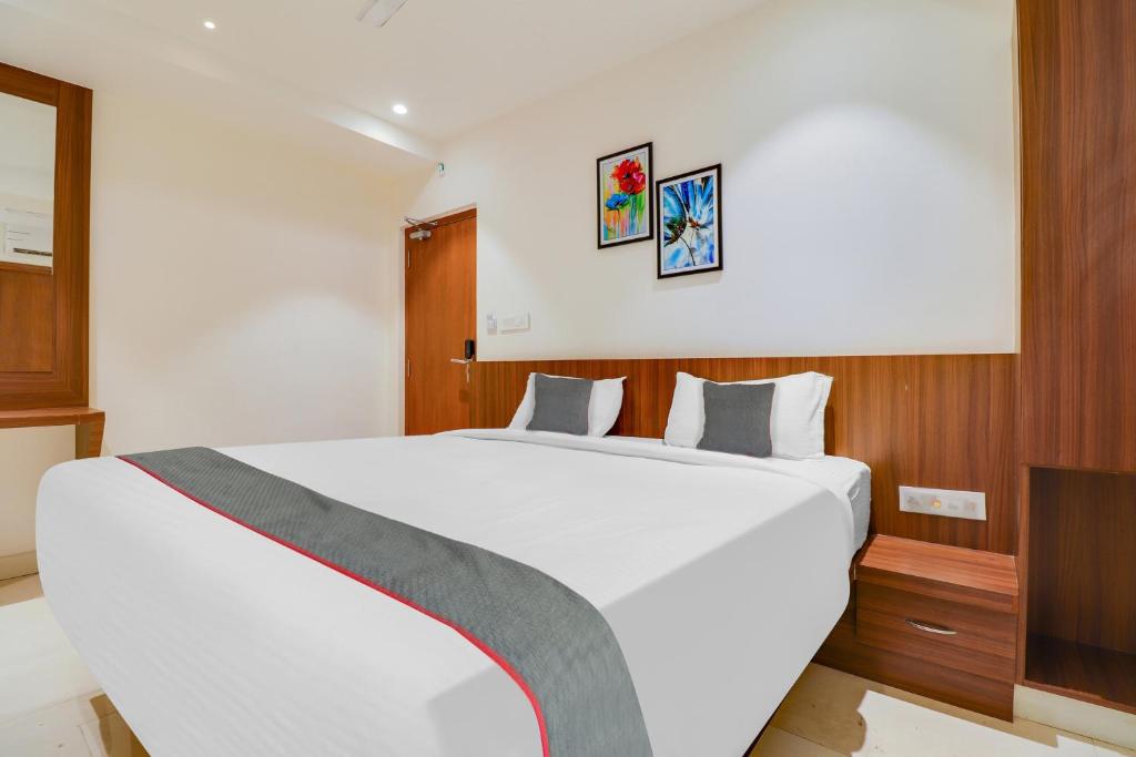 a bedroom with a large white bed in a room at Super Townhouse 1144 Hotel RCC 7 Lamps in Alipur
