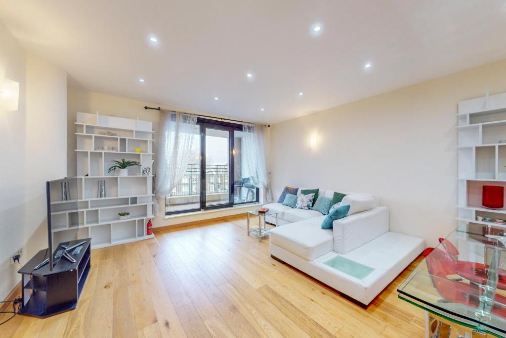 a living room with a white couch and a table at Beautiful 2Bed Apartment with lift in Kensington in London