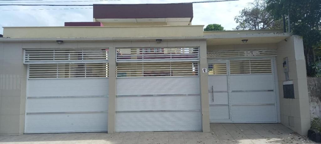 un par de puertas de garaje delante de una casa en Um lugar calmo e aconchegante, en Manaus