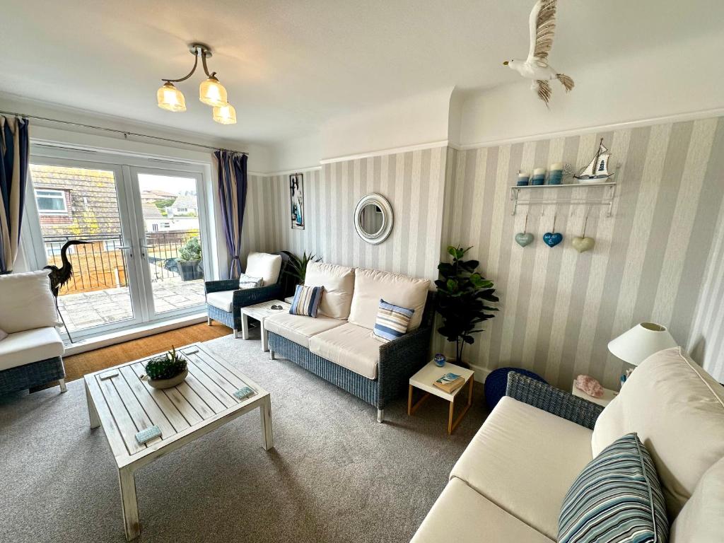 a living room with a couch and a table at Sea View Three Bed Detached Home - With Parking - Next to Beach! in Bournemouth