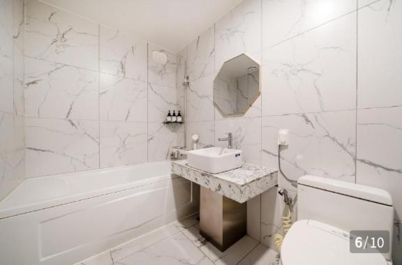 a bathroom with a sink and a toilet and a tub at Hotel 24st Prestige in Seosan