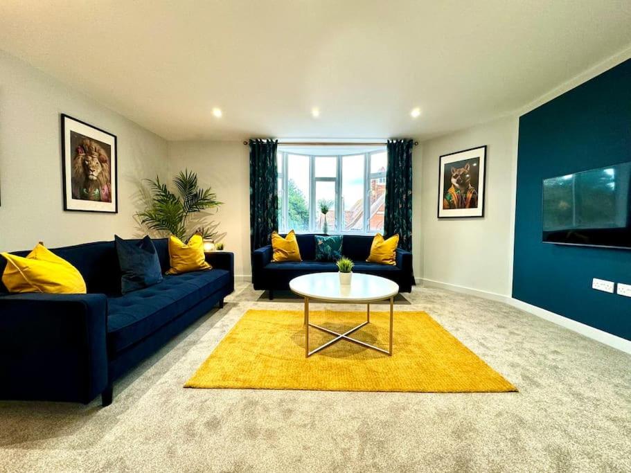 sala de estar con sofá azul y mesa en 3BR Westbourne Delight - Near Beach & Bournemouth!, en Bournemouth