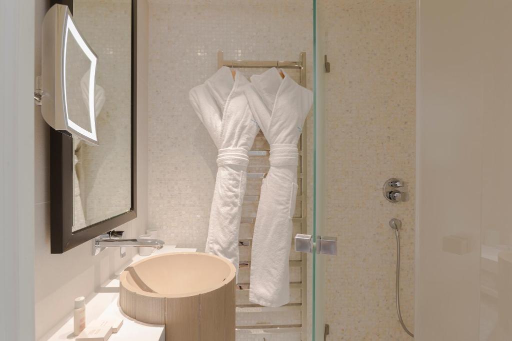 a bathroom with a shower with white towels on a rack at Hôtel Mont-Blanc Chamonix in Chamonix