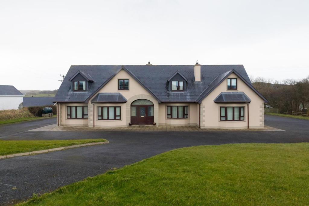 una gran casa blanca con techo negro en Spacious House in beautiful Malin Head, en Keenagh