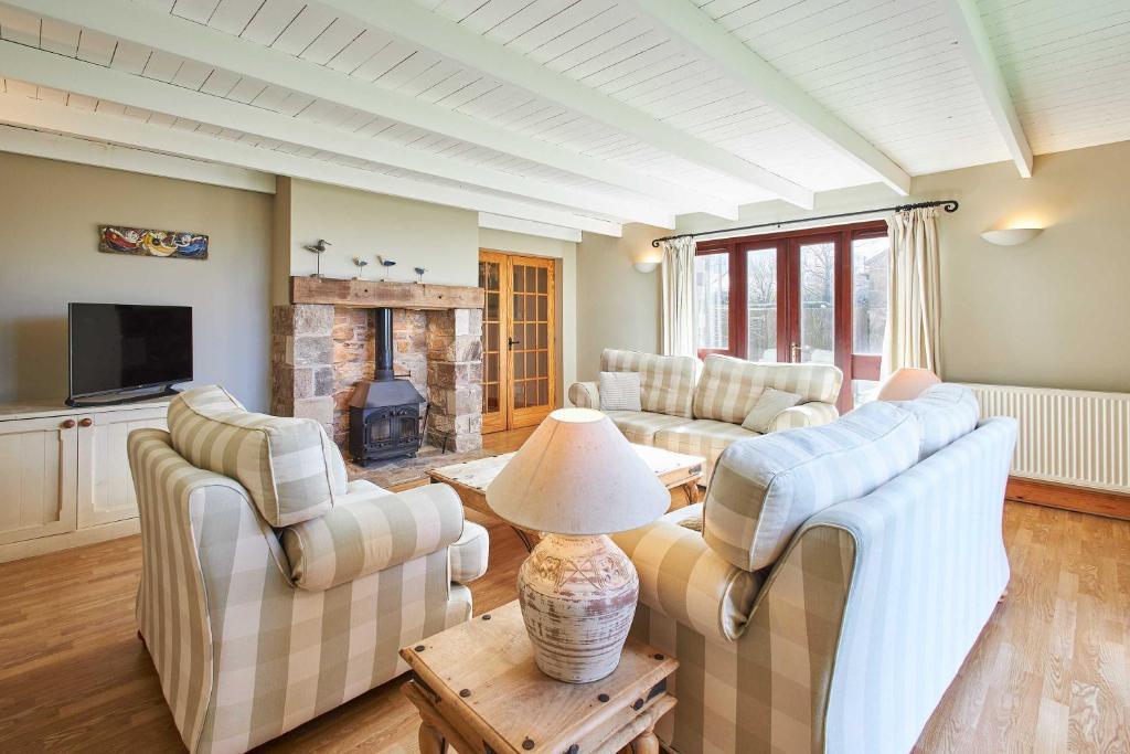 Una sala de estar con sofás y chimenea. en Host & Stay - The Coach House, en Beal