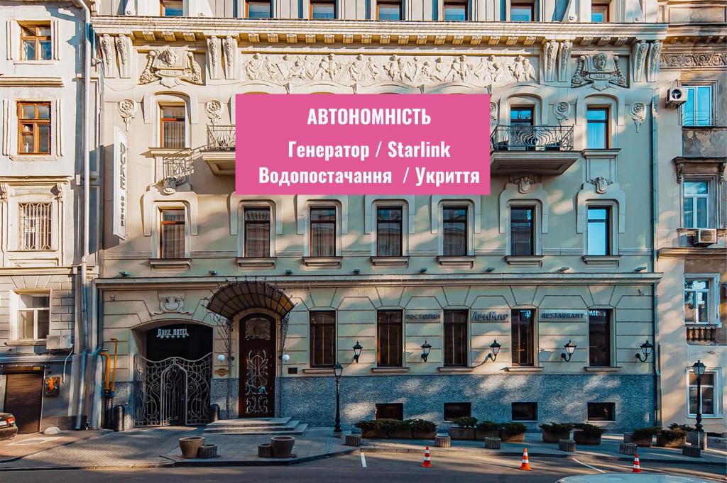 a large building with a pink sign on it at Ribas Duke Boutique Hotel in Odesa