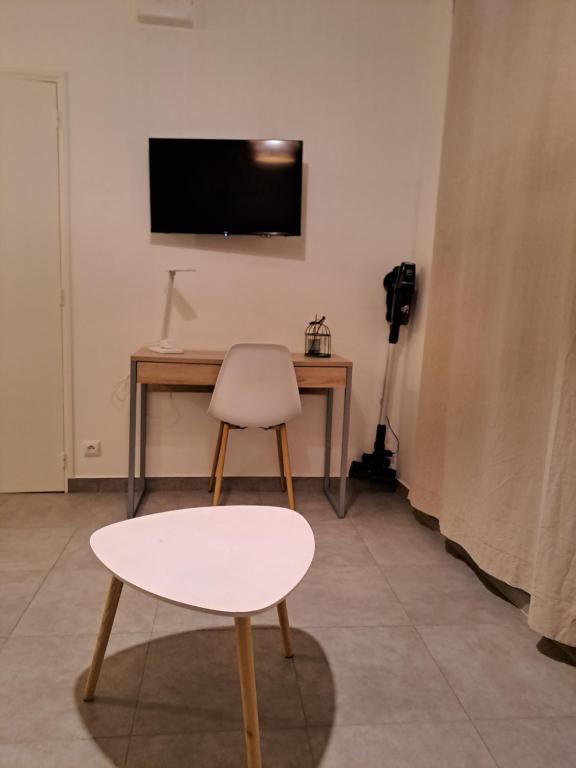 a table and a chair and a desk with a television at Super studio, proche centre ville in Rochefort