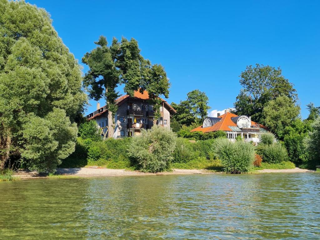 une grande maison sur la rive d'un lac dans l'établissement ChiemseeOase, à Arlaching