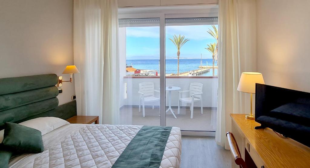 a bedroom with a bed and a view of the ocean at Hotel Levante - Isola d'Elba in Cavo