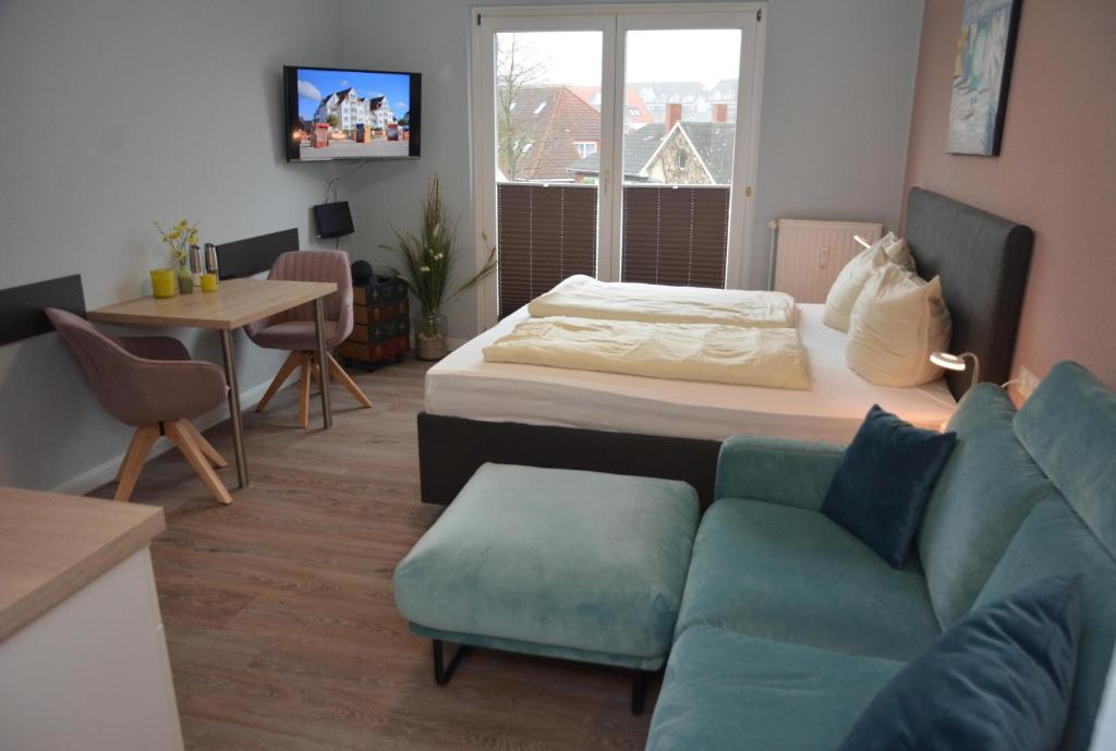 a living room with a bed and a couch at Strandhotel 21 in Laboe