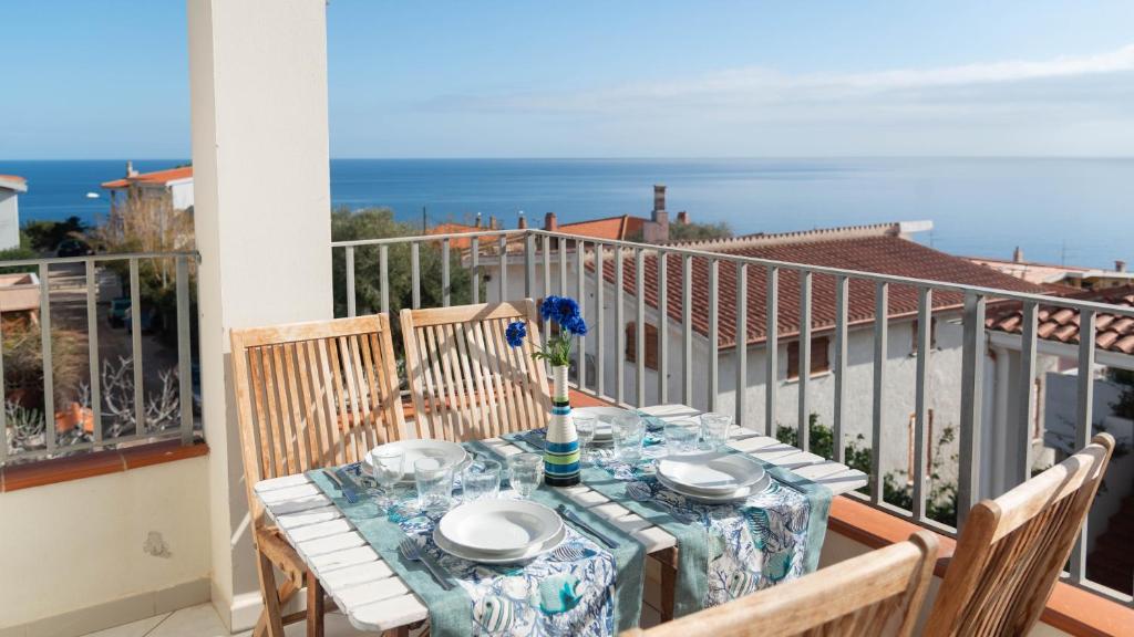 a table on a balcony with a view of the ocean at Green and Blue vista mare Cala Gonone in Cala Gonone