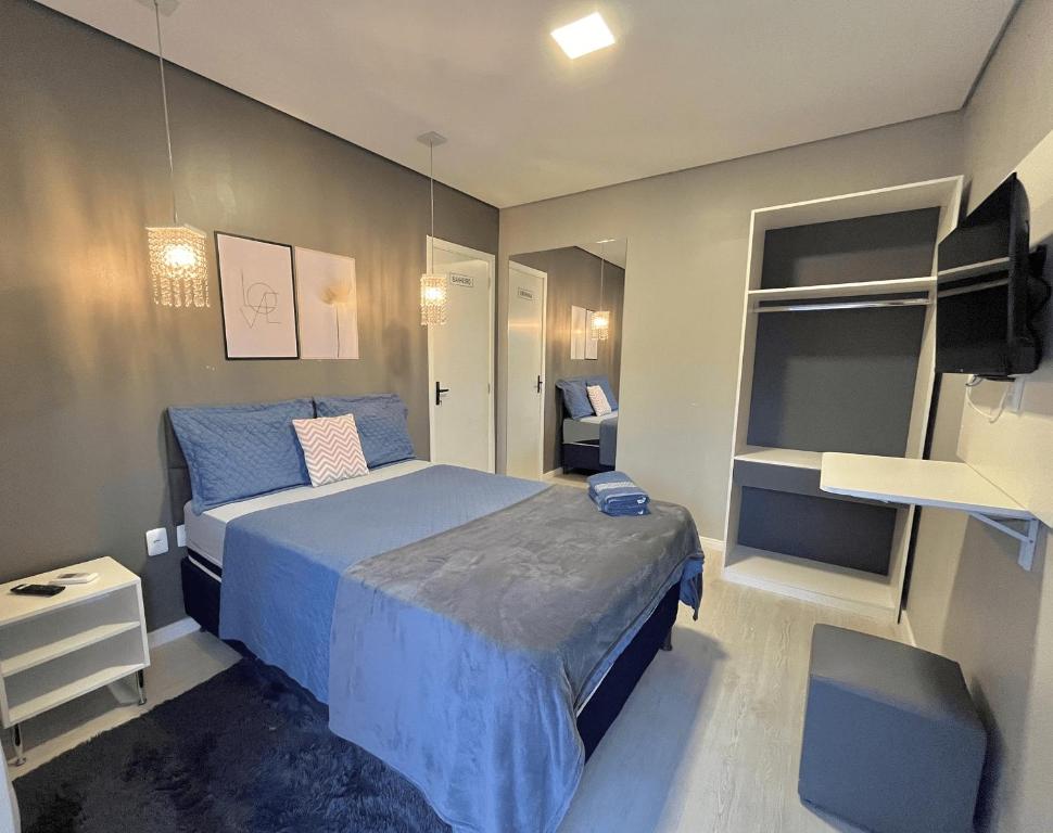 a bedroom with a blue bed and a tv at Hotel Manaus - Dom Pedro I in Manaus