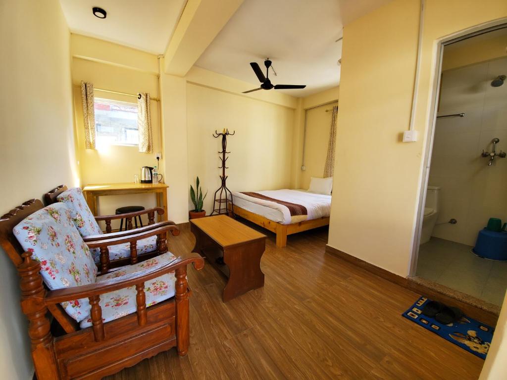 uma sala com um quarto com uma cama e uma cadeira em santoshi guest house em Pokhara