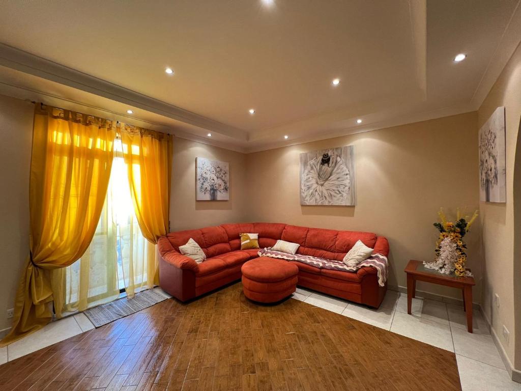 een woonkamer met een rode bank en een raam bij Serene Haven Apartment with three specious bedrooms in Marsaxlokk