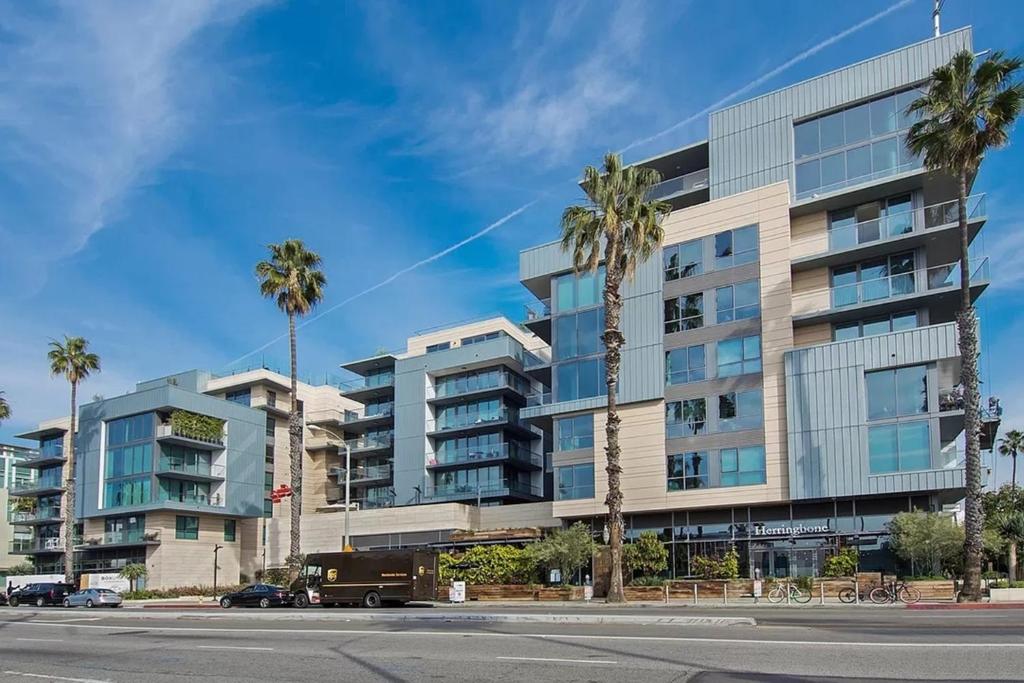 a tall building with palm trees in front of a street at Santa Monica Two Bedroom Apartment With Amazing Views in Los Angeles