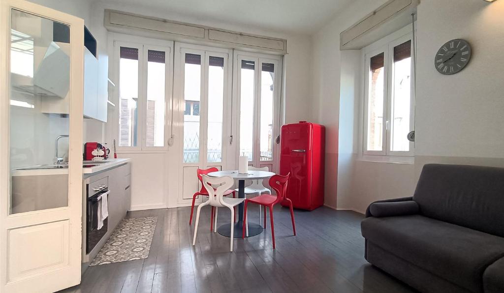 a kitchen with a small table and a red refrigerator at SAHI - Residenza Bianca di Savoia in Milan