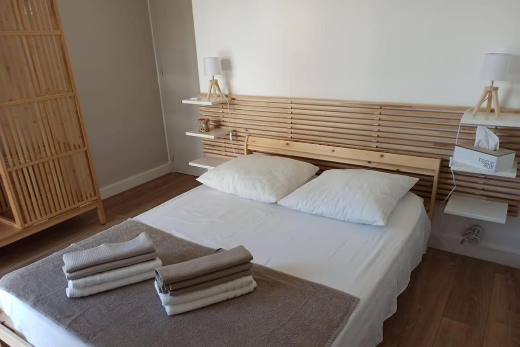 - une chambre avec un grand lit blanc et trois oreillers dans l'établissement T1 Centre Proche du Port et des Plages Garage Climatisation Wifi, à Carry-le-Rouet