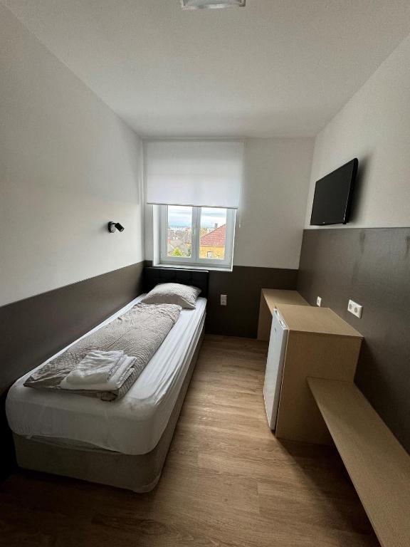 a small bedroom with a bed and a window at F Hotel in Hörsching