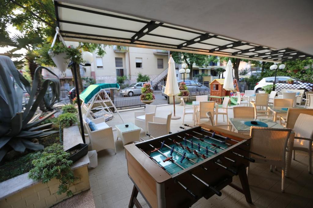 um pátio com uma mesa, cadeiras e um guarda-sol em villa Anny em Rimini