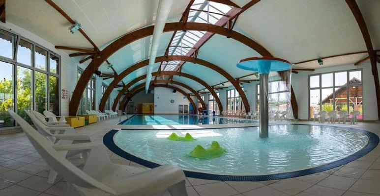- une grande piscine dans une grande pièce avec des chaises et un bâtiment dans l'établissement Mobilhome 422 3ch/1 sdb camping 4* La Réserve SIBLU Gastes, à Gastes