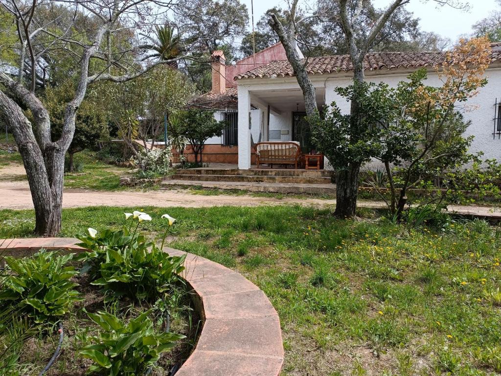 a house with a walkway in front of a yard at Alojamientos Cabezo del Gato in Aracena