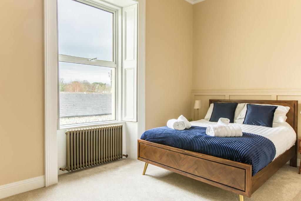 a bedroom with a bed and a large window at Greystones Harbour Apartments in Greystones