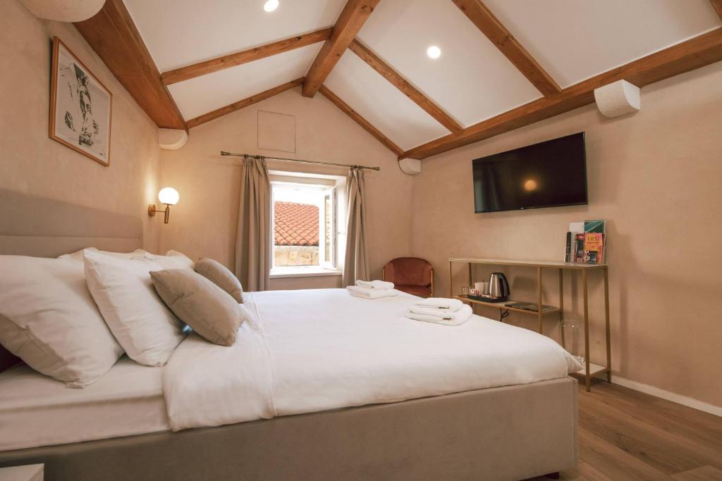 a bedroom with a large white bed with a window at Mascheroni Luxury Rooms in Dubrovnik