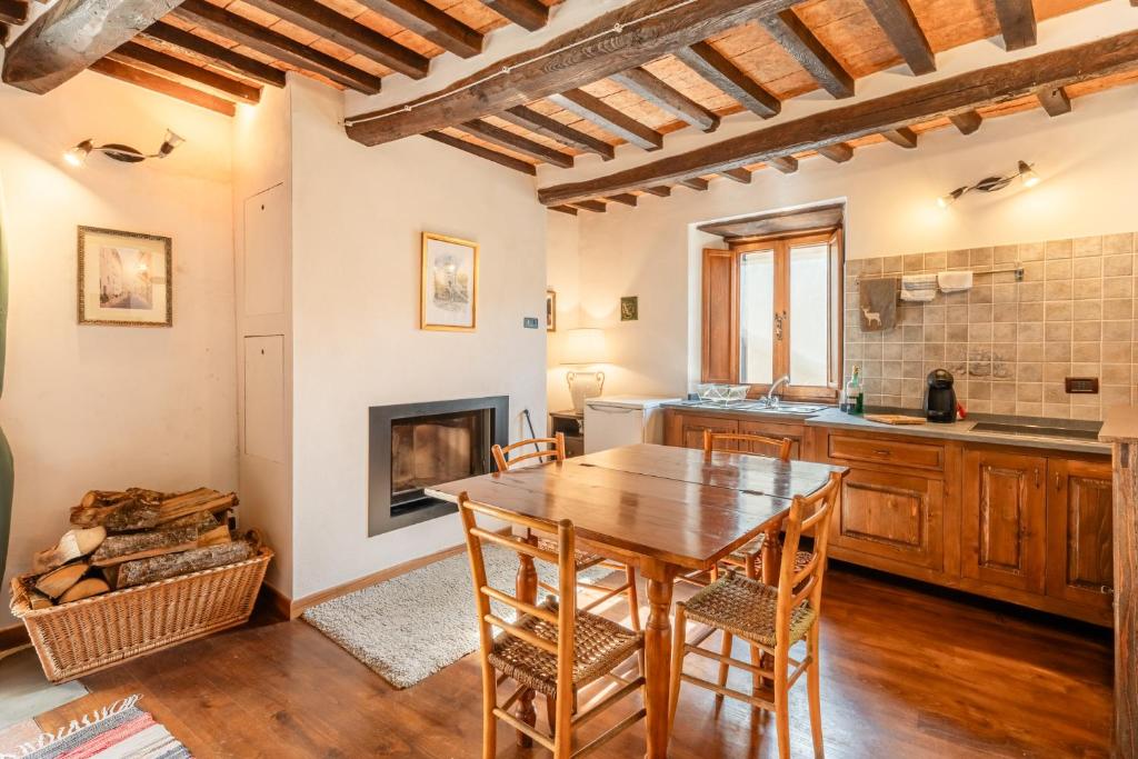 eine Küche mit einem Holztisch und einem Kamin in der Unterkunft Dimora la Rocca in Gallicano