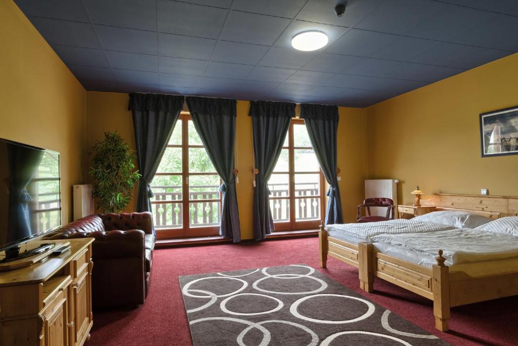 ein Schlafzimmer mit einem Bett, einem Sofa und Fenstern in der Unterkunft Casino & Hotel Eldorado in Česká Kubice
