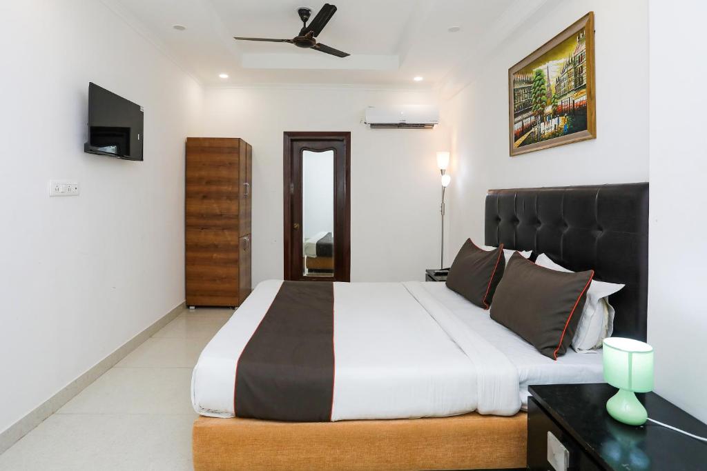 a bedroom with a large bed with a black headboard at Collection O Hotel Residency Near Dwarka Sector 21 Metro Station in New Delhi