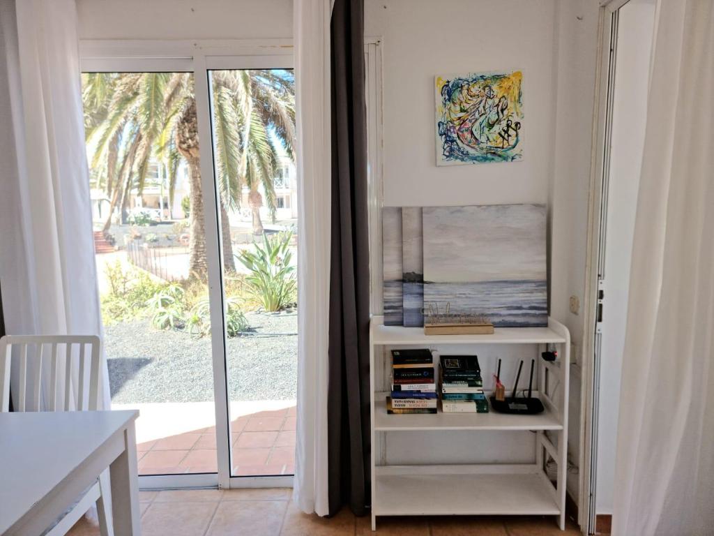a room with a book shelf next to a sliding glass door at Piccola Oasi in Corralejo