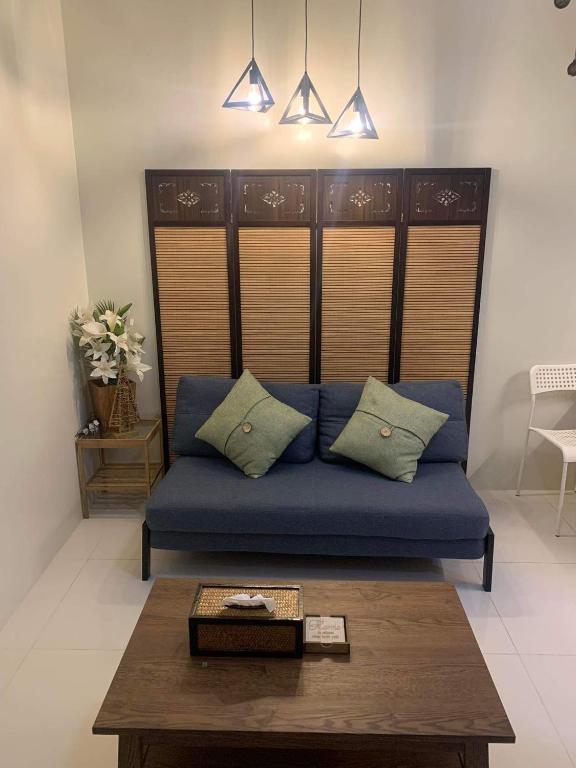 a blue couch in a living room with a table at Brenthill Condo (Sandstone Unit) in Baguio