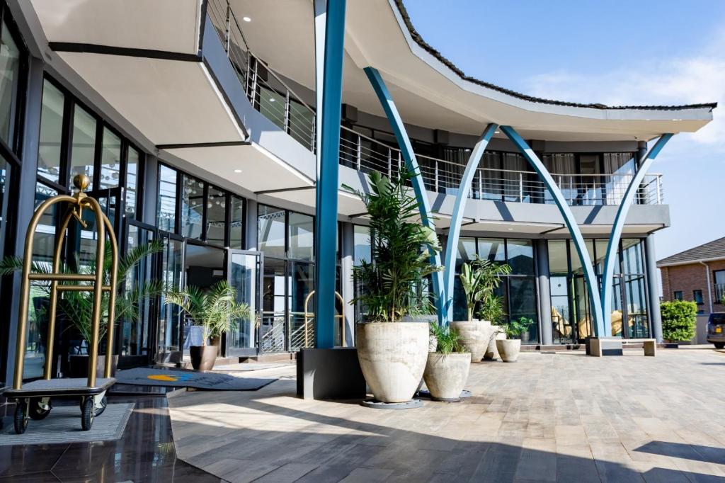 um edifício com vasos de plantas à sua frente em Sigelege Boutique Hotel em Lilongwe