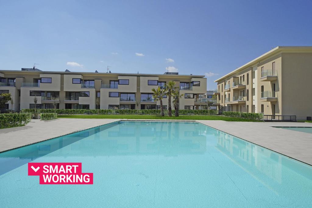 uma piscina em frente a um complexo de apartamentos em Katya Resort Apartments by Wonderful Italy em Desenzano del Garda