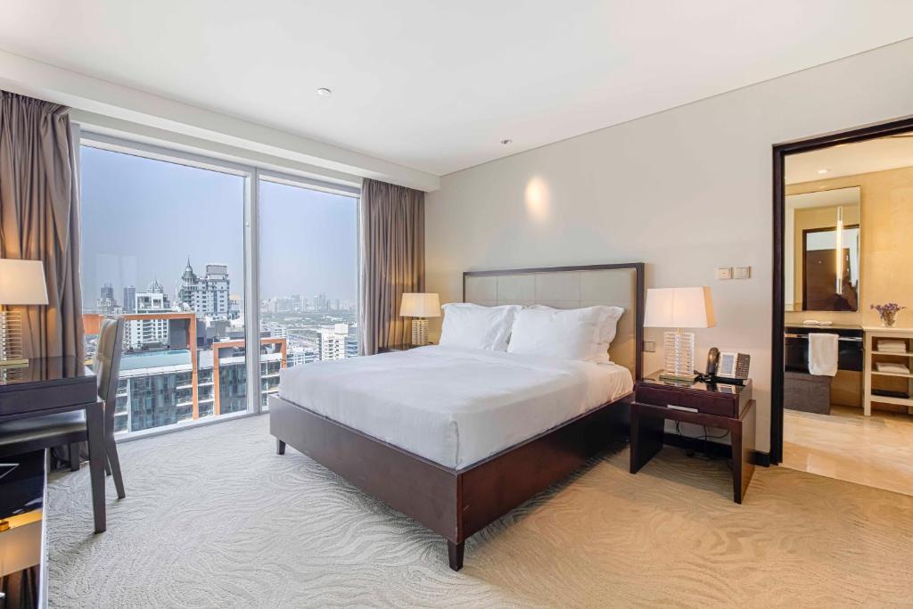 a hotel room with a bed and a large window at Daniels 1BR at Address Marina High Floor with Marina View in Dubai