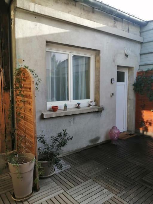 une maison avec une fenêtre et un rebord de fenêtre orné de plantes dans l'établissement Studio Indépendant avec terrasse proche Paris, à Épinay-sur-Seine