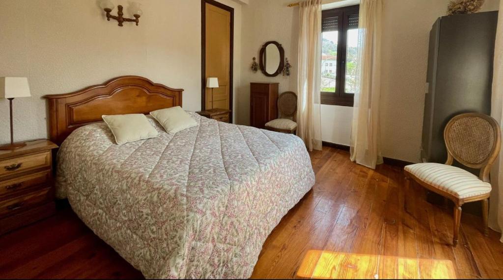 a bedroom with a large bed and a wooden floor at La Cristina in Berástegui