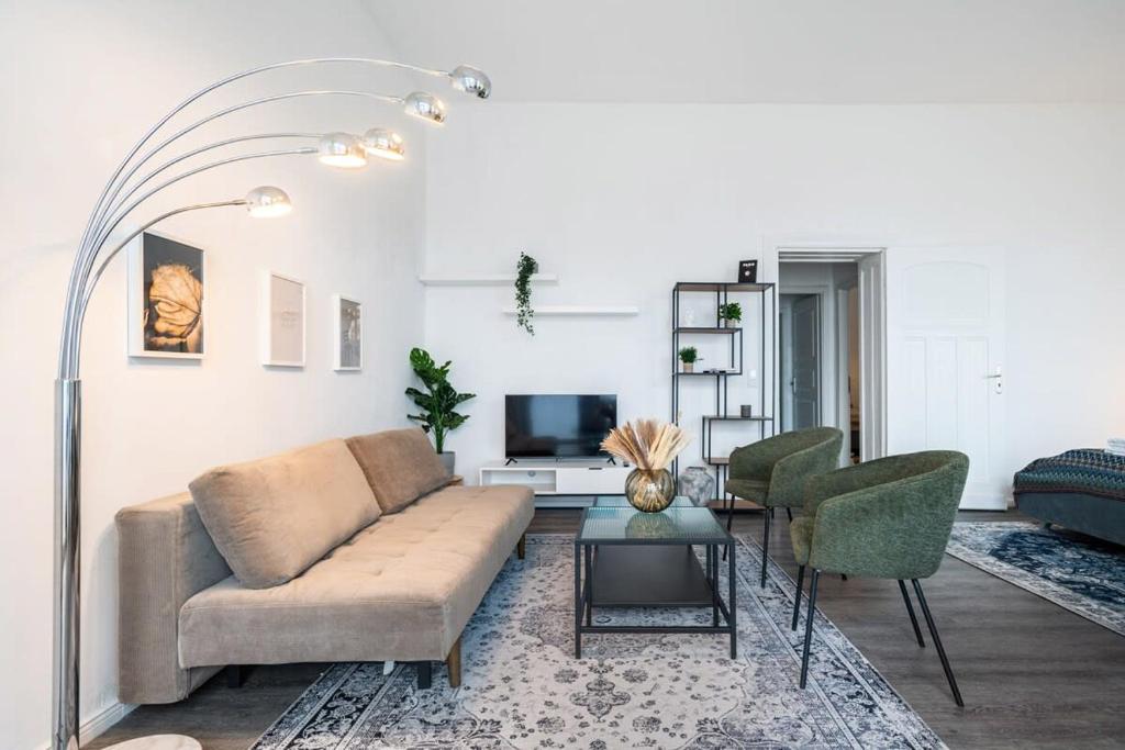 een woonkamer met een bank en stoelen en een tv bij City Apartment: Homeoffice und Erholung vereint! in Berlijn