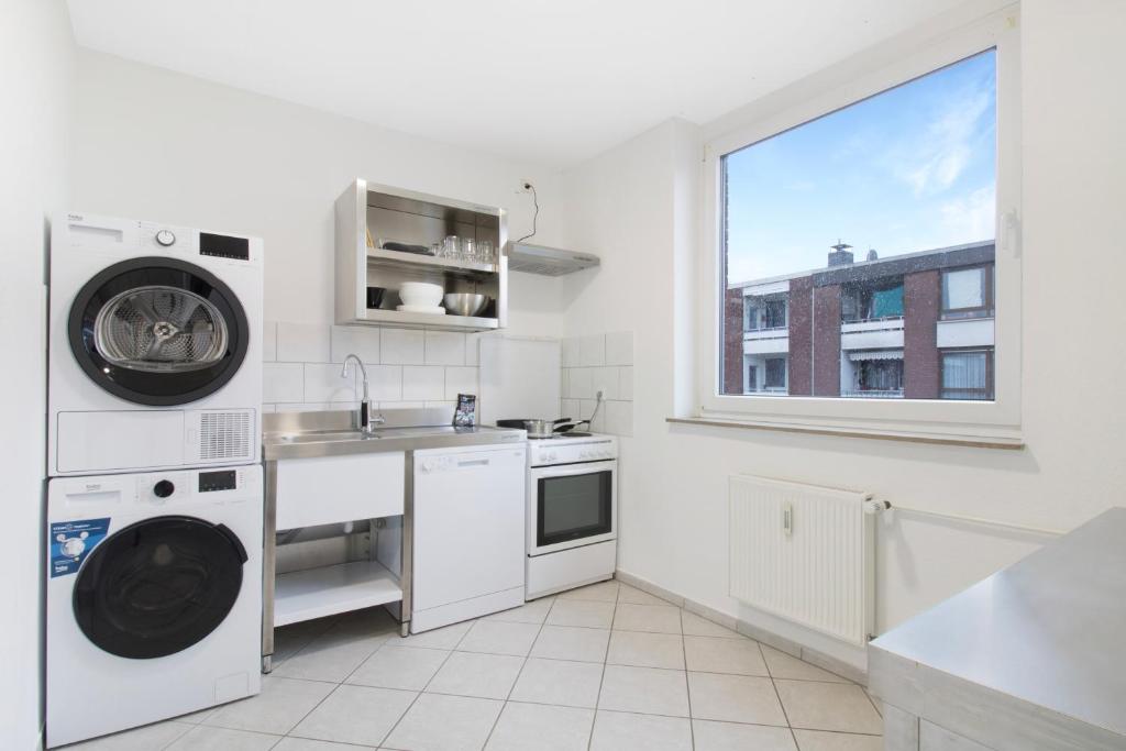 eine weiße Küche mit einem Waschbecken und einer Waschmaschine in der Unterkunft Schickes Apartment mit Balkon in Dorsten