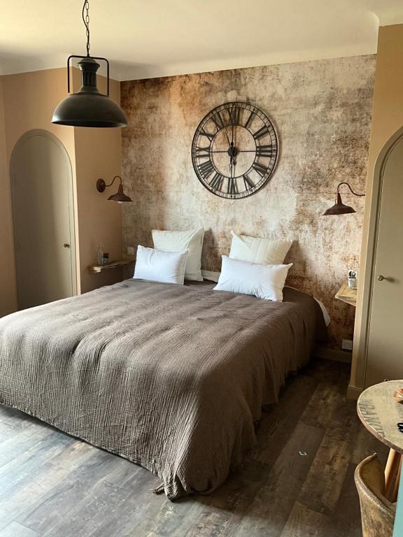 a bedroom with a large bed with a large clock on the wall at Chambres d&#39;hôtes Le Montagné in Villeneuve-lès-Avignon