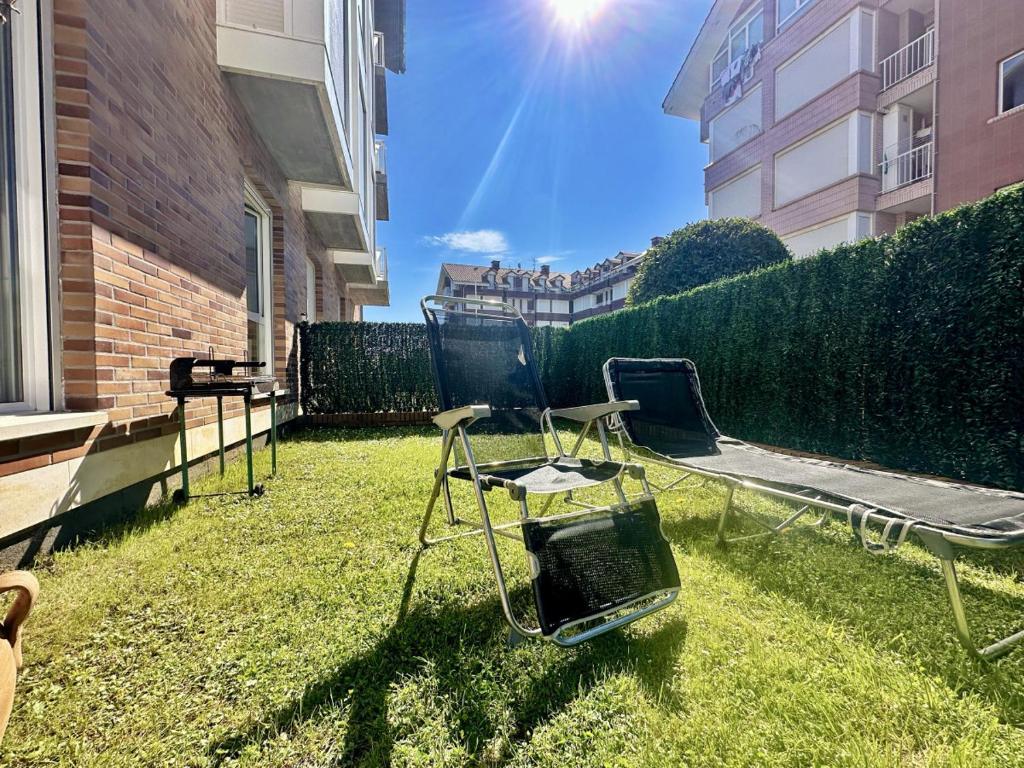 un patio con una silla y una mesa en el césped en Costa Verde - 6006, en Noja