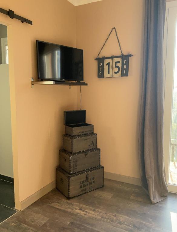 a staircase with a tv and a clock on the wall at Chambres d&#39;hôtes Le Montagné in Villeneuve-lès-Avignon