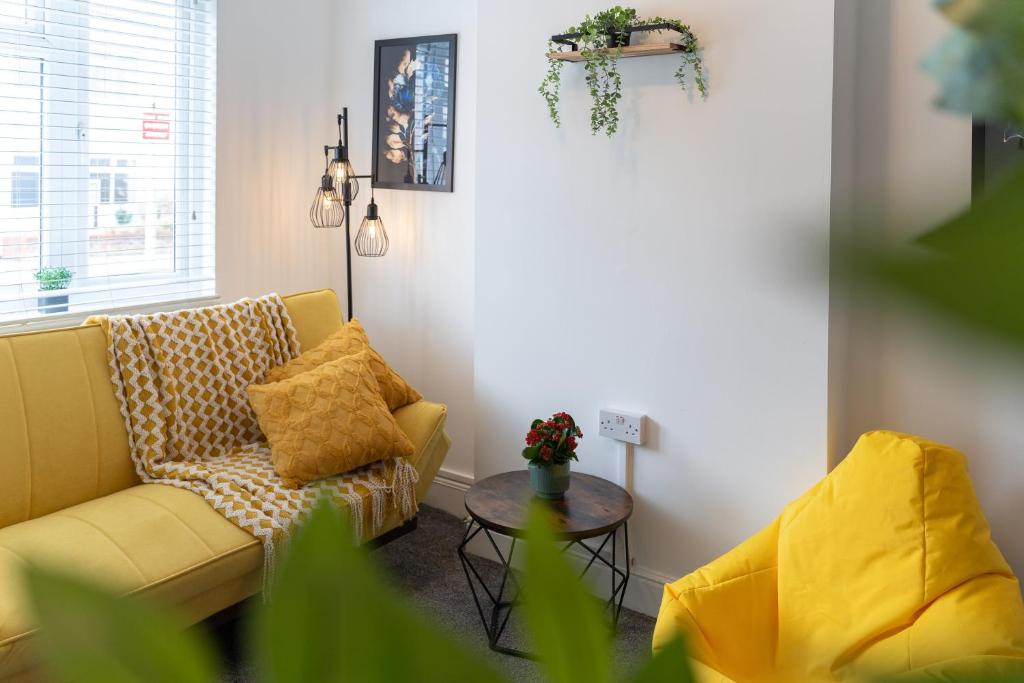 Una sala de estar con un sofá amarillo y una mesa. en Open Mind Property - Luxury 3 Beds & Free Parking, en Portsmouth