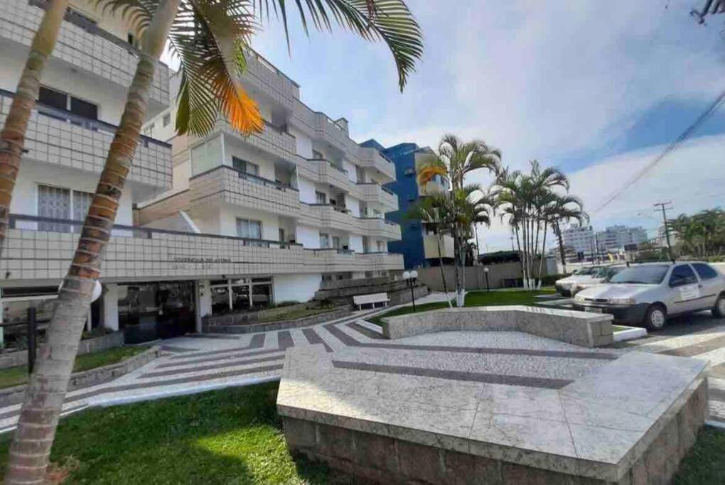a building with a palm tree in front of it at Ape Caiobá vznho boliche e Assoc Caixa Econômica in Matinhos